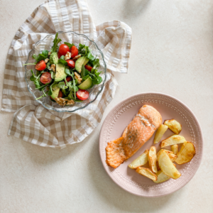 plato de salmón con patata y plato de ensalada de canónigos
