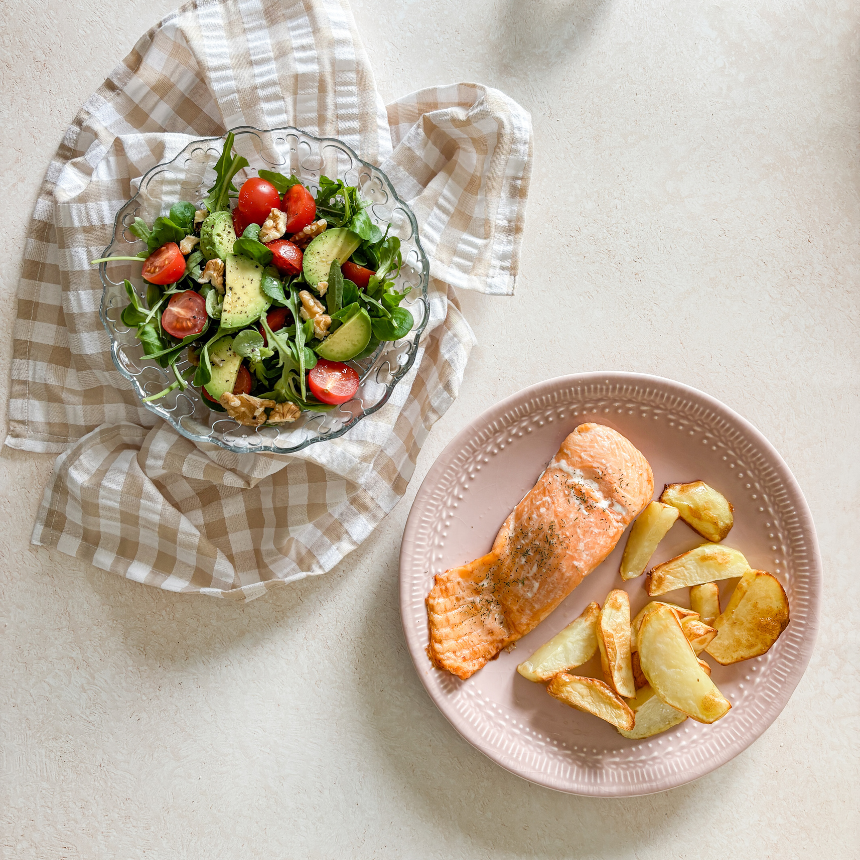plato de salmón con patata y plato de ensalada de canónigos